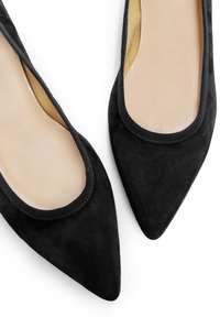 Bailarinas de ante negro con puntera puntiaguda y una plantilla beige suave, además de un ribete elástico negro alrededor de la abertura. Diseño simple y elegante.