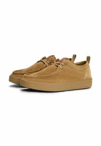 Beige Wildledersneaker mit glatter Textur, abgerundetem Zehenbereich und schlankem Design. Verfügt über eine Schnürung vorne und eine stabile Gummisohle.