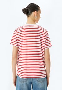 Rød og hvid stribet kortærmet t-shirt, lavet af blødt bomuld, med rund halsudskæringer og en afslappet pasform.