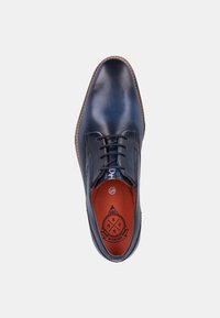Chaussure derby en cuir bleu marine avec une texture lisse, une construction robuste et une semelle intérieure orange contrastante. Équipée de lacets et d'un bout rond.