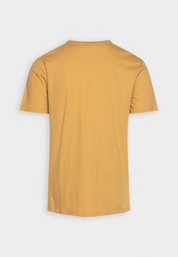 T-shirt à manches courtes en coton jaune moutarde. Design simple à col rond, texture lisse, dos uni sans motifs ni graphiques.