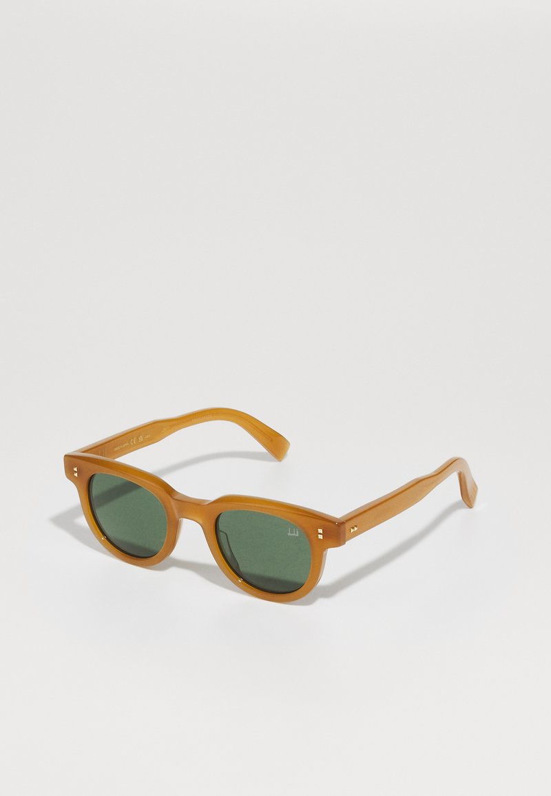 Bruine transparante zonnebril met groene lenzen, met een vierkante vorm, dunne armen en gouden accentdetails bij de scharnieren.