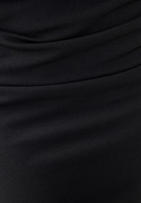Black fitted dress featuring soft, smooth texture with gathered detailing along the fabric, creating subtle folds.