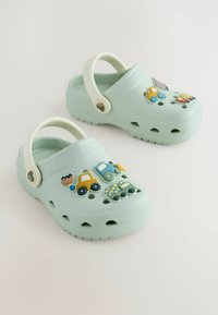 Svetlozelené šľapky z gumového materiálu, s vyvýšenými ozdobnými príveskami v tvare vozidiel a ventilačnými otvormi na stranách.