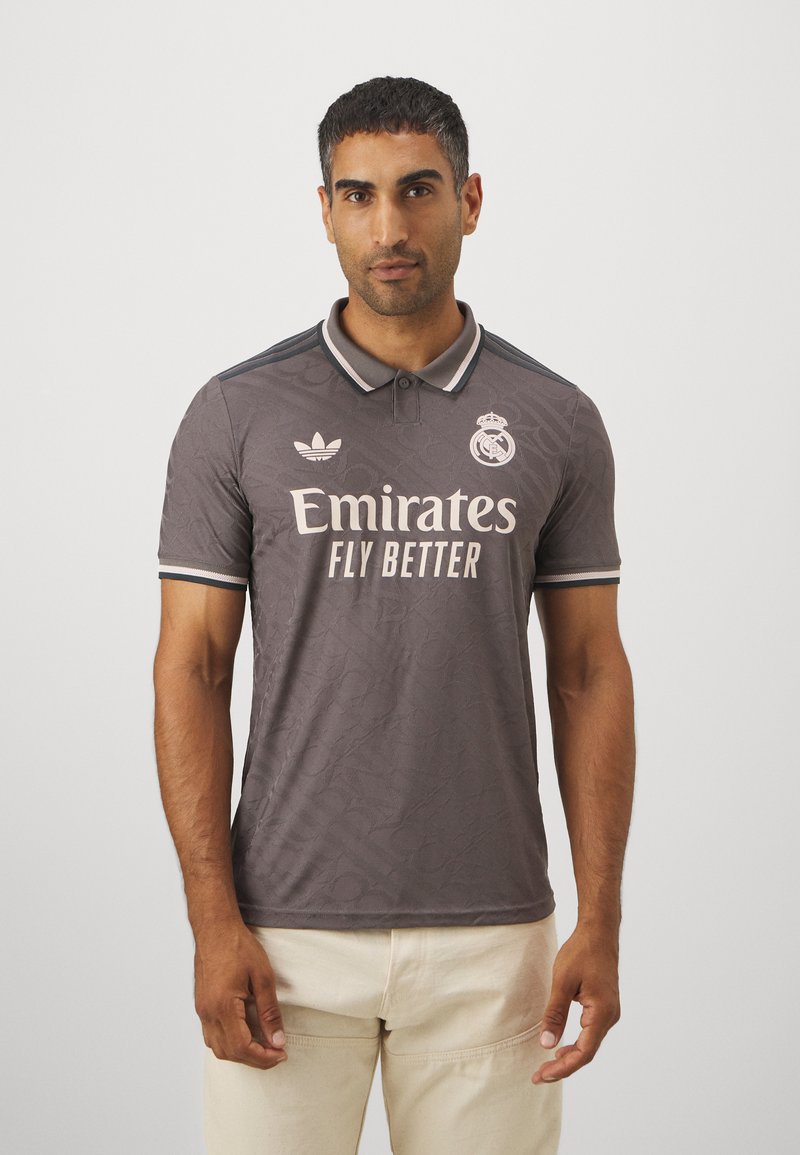 Grå polo skjorte med subtilt mønster, der har hvid "Emirates Fly Better" logo og emblem, mørkeblå krave og ærme detaljer, fremstillet af åndbart stof.