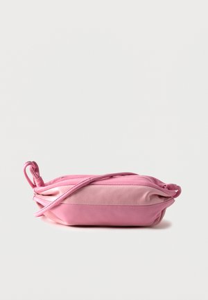 Soft pink leather crossbody bag lying flat with a thin adjustable strap and zipper closure against a plain background.