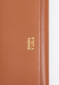 Cartera de cuero marrón texturizado con el logotipo dorado en relieve "BIMBA Y LOLA" en la parte frontal, con bordes limpios y un acabado suave.