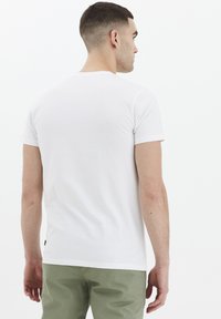 Hvit, kortermet t-skjorte laget av bomull med rund hals. Fitted design, glatt tekstur, og ingen synlige mønstre eller detaljer.