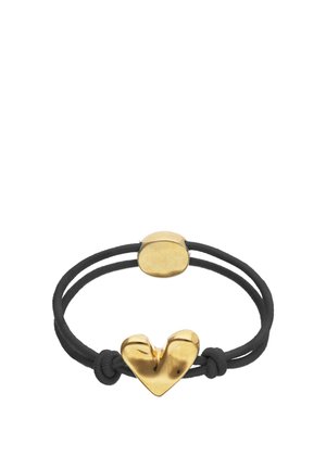Pulsera de doble cordón negro con un charm central irregular en forma de corazón dorado y un cierre ovalado dorado y liso.