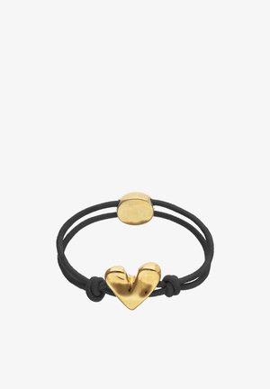Pulsera de doble cordón negro con un charm central irregular en forma de corazón dorado y un cierre ovalado dorado y liso.