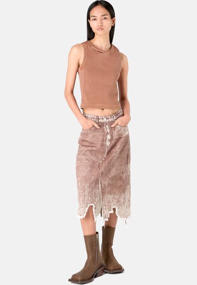 Bruine geribbelde tanktop gecombineerd met een vervaagde, versleten denimrok. Model draagt bruine kniehoge laarzen met een blokhak.