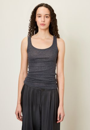 Dunkelgraues, tailliertes Tanktop aus weichem, dehnbarem Stoff. Es verfügt über breite Träger und einen Rundhalsausschnitt, kombiniert mit lockeren schwarzen Hosen.
