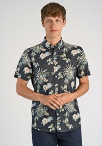 Camisa negra de manga corta con un patrón floral tropical en verdes y rosas, que presenta un cuello con botones y un dobladillo recto.