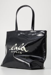 Borsa a tote nera lucida con due manici, caratterizzata da un logo bianco "lala BERLIN". Realizzata in materiale liscio con una forma strutturata.