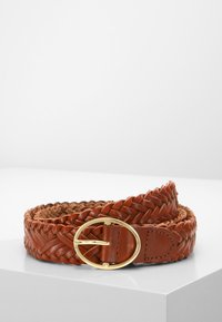 Geweven bruine leren riem met een ronde gouden gesp, voorzien van een textuur op het riemdeel en een gladde afwerking op het gespgedeelte.