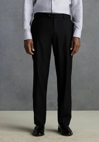 Pantalons noirs à coupe droite, avec une texture lisse et un tissage de tissu uniforme. Comprend des passants de ceinture et un fermoir à l'avant.
