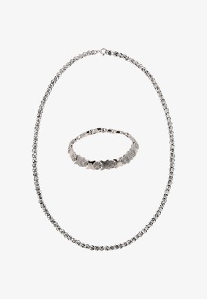 Ezüst ékszerszett, amely egy láncnyakláncot és egy karkötőt tartalmaz, összefonódó szemekből áll, mintázott díszítésekkel, sima felülettel és fényes textúrával.