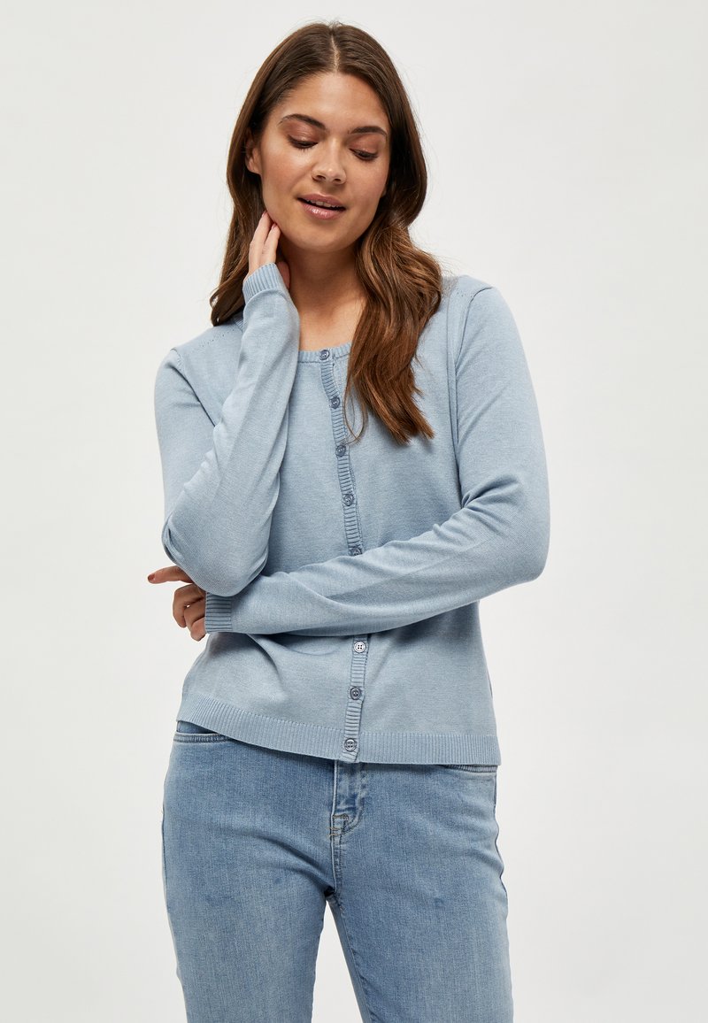 Cardigan azzurro chiaro realizzato in morbido tessuto lavorato a maglia, con scollo rotondo, chiusura con bottoni e polsini e orlo a coste.