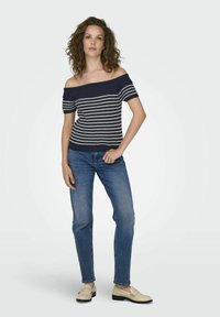 Top de punto de rayas navy y blanco con escote bardot y mangas cortas, combinado con jeans rectos azules y mocasines crema.