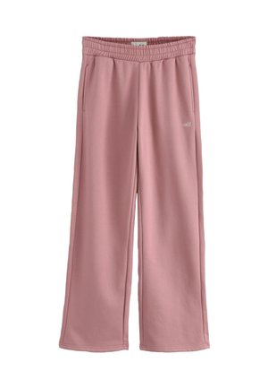 Un pantalon de survêtement rose clair avec une taille élastique, deux poches latérales et une coupe ample avec des détails de couture et un logo subtil.