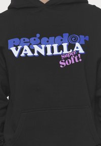 Černá mikina s kapucí a přední kapsou, na které se nachází barevný text: "pegg@dor" v modré, "VANILLA" v bílé a "super Soft!" v růžové. Jemná textilie.