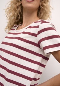 Gestreept t-shirt in crèmekleur met bordeauxrode horizontale strepen. Korte mouwen, ronde halslijn, gemaakt van lichtgewicht stof, relaxte pasvorm.