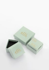 Ljust gröna presentlådor i olika storlekar, med guldtext och en mjuk textur. Inkluderar en hexagonal låda och en mindre rektangulär låda.