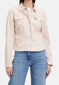 Světle růžová džínová bunda s přiléhavým střihem, špičatým límcem a stříbrnými kovovými knoflíky. Obsahuje dvě náprsní kapsy a dlouhé rukávy.