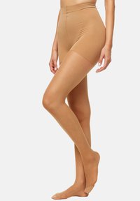 Pantalones cortos beige sin costuras con una cintura alta y una textura suave, que presentan un diseño ajustado que se extiende hasta la mitad del muslo, mejorando la comodidad.