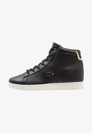 Czarny, wysokiej cholewce skórzany sneaker z perforowanymi bokami, złotymi oczkami, złotym logo krokodyla i białą gumową podeszwą.
