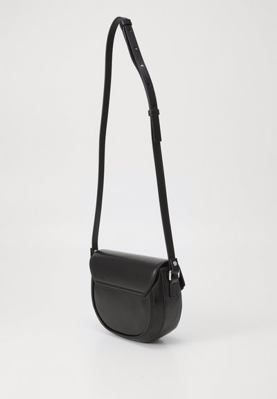 Svart läder crossbody-väska med en böjd form, lockstängning, justerbar rem och silverfärgade detaljer. Slät yta med minimalistisk design.