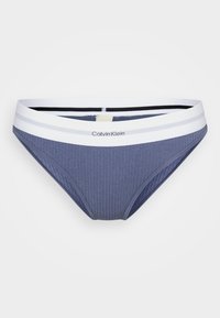 Klassiske bikini-truser i ribbestrikket bomull i marineblått med en hvit elastisk midjebånd som har svarte og grå detaljer, samt "Calvin Klein"-logo.