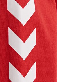 Tissu rouge avec trois larges bandes blanches en forme de chevron pointant vers le bas, alignées verticalement.