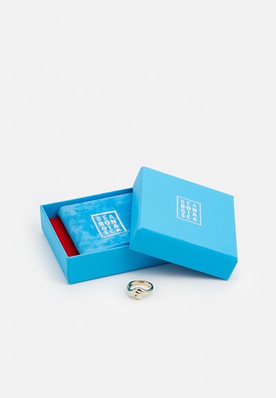 Goldring mit Wellenmuster, präsentiert in einer hellblauen Schachtel mit roten Akzenten und einem Samtinterieur, mit dem Markenlogo auf dem Deckel.