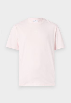 Roze katoenen T-shirt met korte mouwen, ronde hals en een klein, wit Lacoste-logo op de borst. Eenvoudig, ongecompliceerd ontwerp.