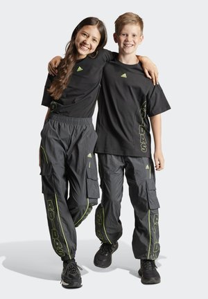 Sorte atletiske T-shirts og cargo-bukser med neongrønne detaljer; elastiske taljebånd og flere lommer; sporty design og behagelig pasform.