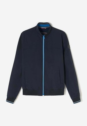 Veste de bombardier navy avec une fermeture éclair bleue, des poignets et un col côtelés. Elle présente une texture lisse, des poches latérales et un logo sur la manche gauche.