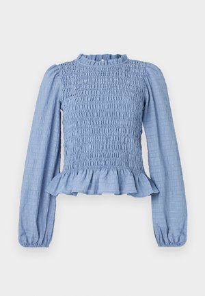 Bluză smockată de culoare albastru deschis, cu mâneci lungi, guler plisat, hem peplum și țesătură texturată cu un model încrețit.