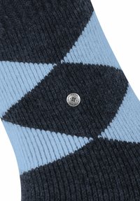Calze a maglia di colore blu scuro con motivo a diamante blu chiaro, dotate di un bottone logo argentato. Texture a coste vicino alla parte superiore per elasticità.