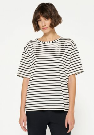 Camiseta de rayas en crema y negro, con un cuello redondo, mangas cortas y un ajuste relajado. La tela parece suave y ligera.