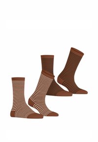 Drie paar bruine sokken: één effen, één met witte strepen en één met zwarte strepen. Gemaakt van een soepele stof met een comfortabele pasvorm.