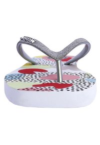 Chanclas con una tira de purpurina plateada y una plantilla colorida con un patrón de puntos y formas abstractas sobre una suela blanca.