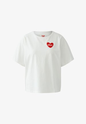 Wit katoenen t-shirt met korte mouwen, met een rood hartvormig borduurwerk met in het midden de tekst "Oui". Simpel ontwerp met ronde hals.