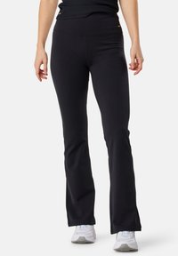 Pantaloni neri a palazzo realizzati in tessuto elasticizzato, con vita alta e delicati dettagli dorati sui fianchi. Texture liscia senza motivi.
