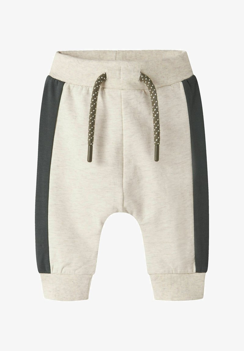 Pantalon de survêtement beige clair avec panneaux latéraux gris foncé, poignets côtelés, et taille avec cordon de serrage orné d’embouts polis et de motifs à pois.