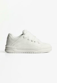 White low-top sneaker with thick white laces, padded collar, and textured sole placed on a plain white background.