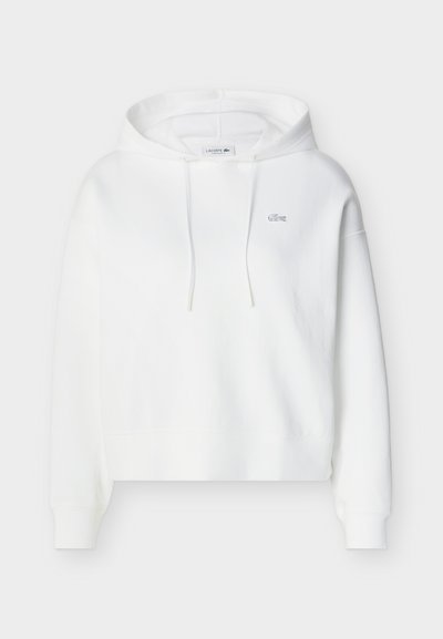 Sweat à capuche blanc à manches longues, avec poche kangourou avant, cordons de serrage et petit logo crocodile Lacoste brodé sur la poitrine.