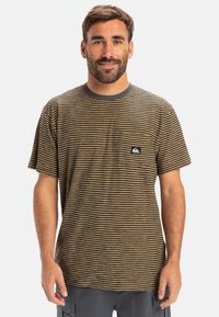 Bruine en marineblauwe gestreepte t-shirt van zacht katoen, met een ronde hals en een klein zakje met een logo aan de linkerkant.