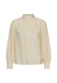 Blouse couleur crème avec manches longues bouffantes, col haut et poignets ajustés, présentée sur fond blanc.