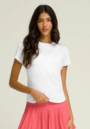 Weißes Kurzarm-T-Shirt mit Rundhalsausschnitt, glatter Textur und schlanker Passform, kombiniert mit einem plissierten rosa Rock.